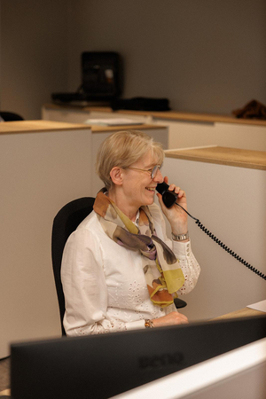 Medewerkster van de backoffice aan de telefoon aan haar bureau