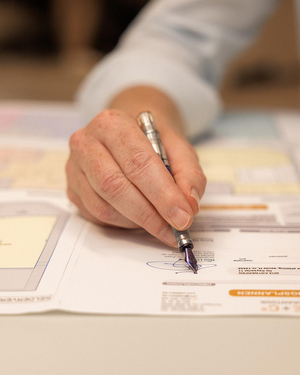 Hand die met een vulpen tekent op een opmetingsplan