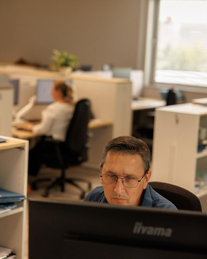 Medewerker van Sabbe aan het werk achter zijn computer op het landmeterskantoor